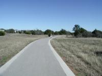 The trail near the trailheads is paved. Go further out and you'll get granite.